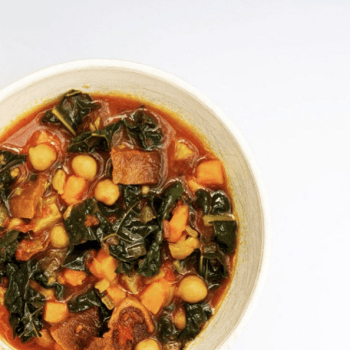 a hardy bowl of soup filled with veggies and kale