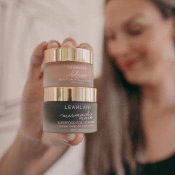 Lisa holds two jars of Leahlani organic skincare products.