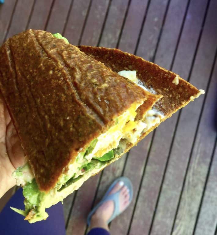 a raw veggie bread sandwich with egg salad inside 