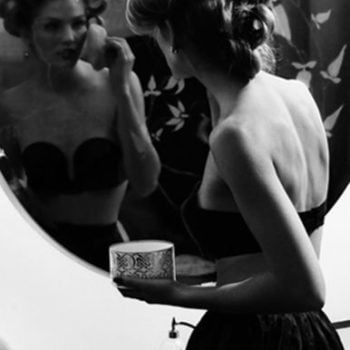 Black and white photo of a girl putting on makeup and getting ready to go out