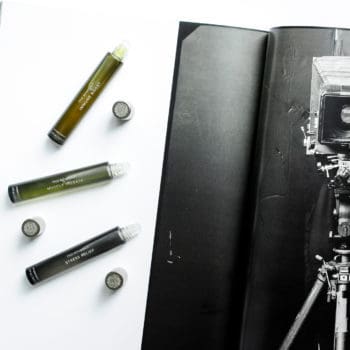 True Botanicals Aromatherapy rollers styled on top of a black and white photo of an old fashioned camera