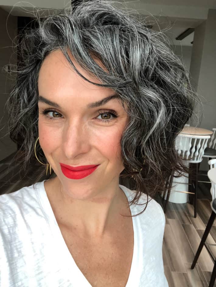 woman with gray hair wearing a bright red lipstick 