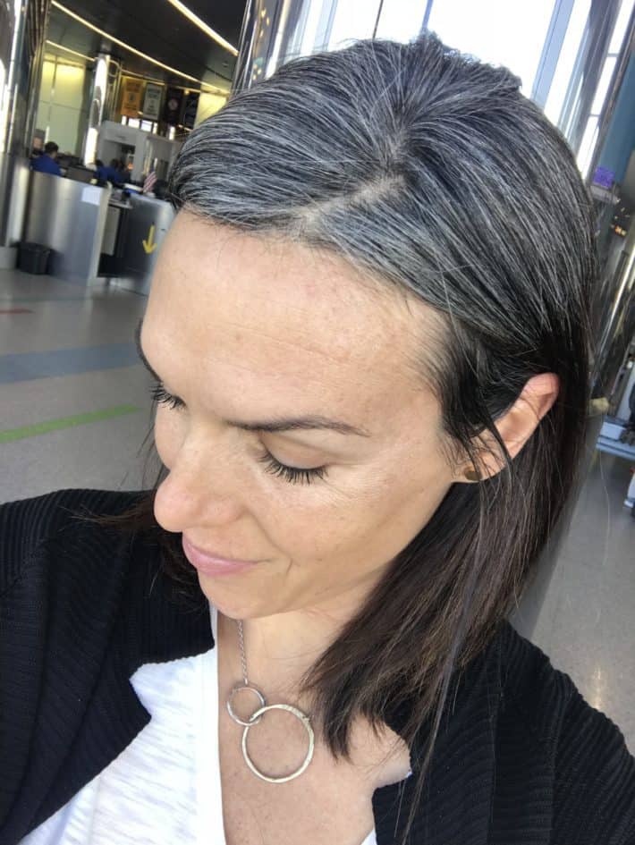 Photo of a woman who
is growing her hair out to be gray. This photo shows what the hair color looks like 6
months into the graying process