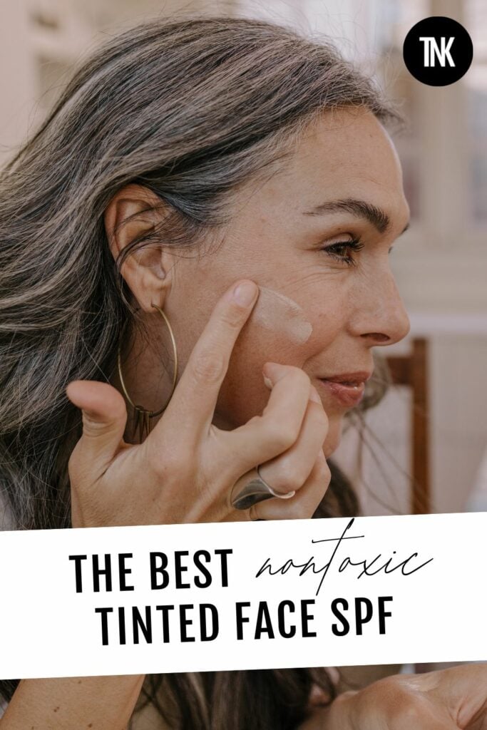 A woman applying tinted face spf to her cheek.