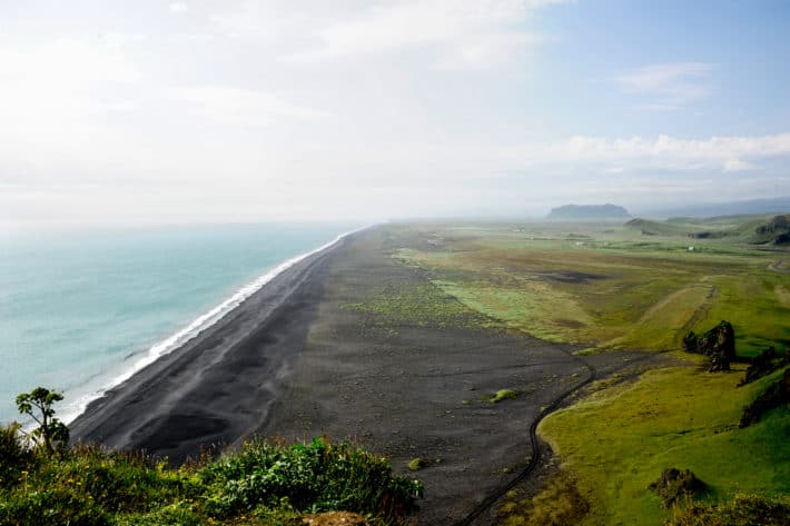 Dyrhólaey from the top looking down at the black sand beaches and forever skyline