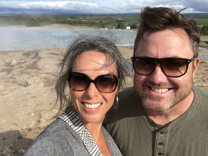 a couple standing in front of Geysir