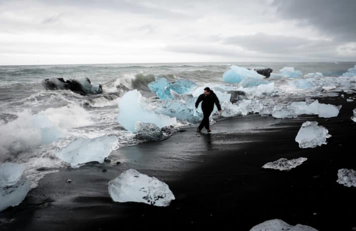 running away from the waves among icebergs at Diamond Beach Iceland