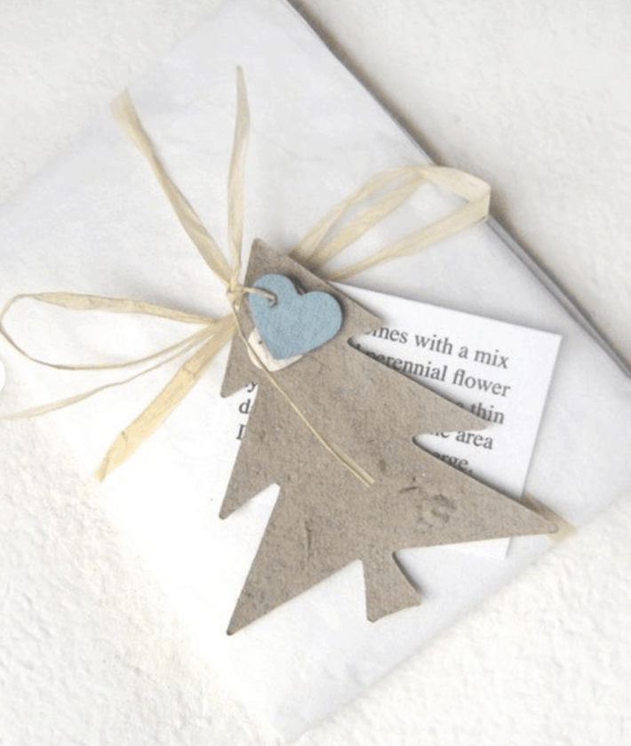 white gift adorned with seed paper cut in the shape of a tree