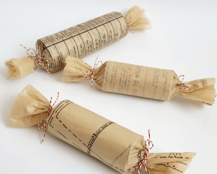 three tube size presents wrapped in sewing patterns