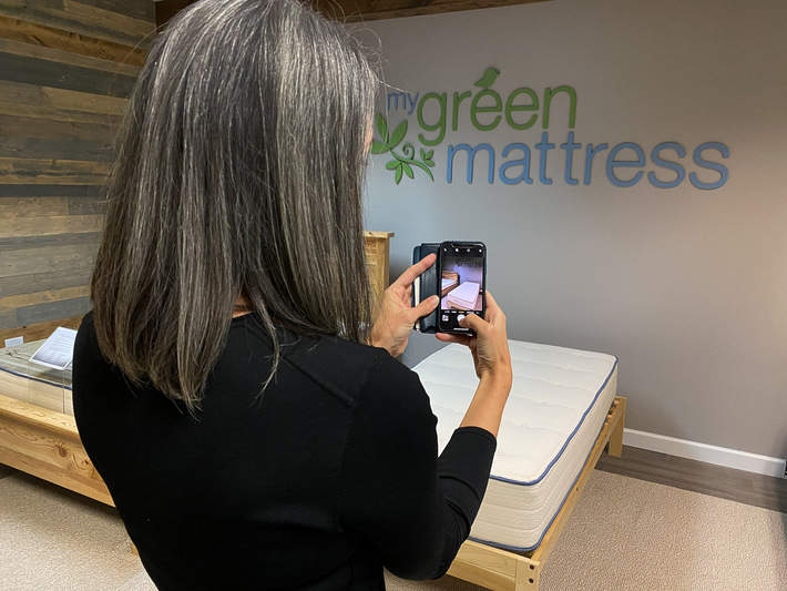 me taking a photo of a my green mattress in the showroom