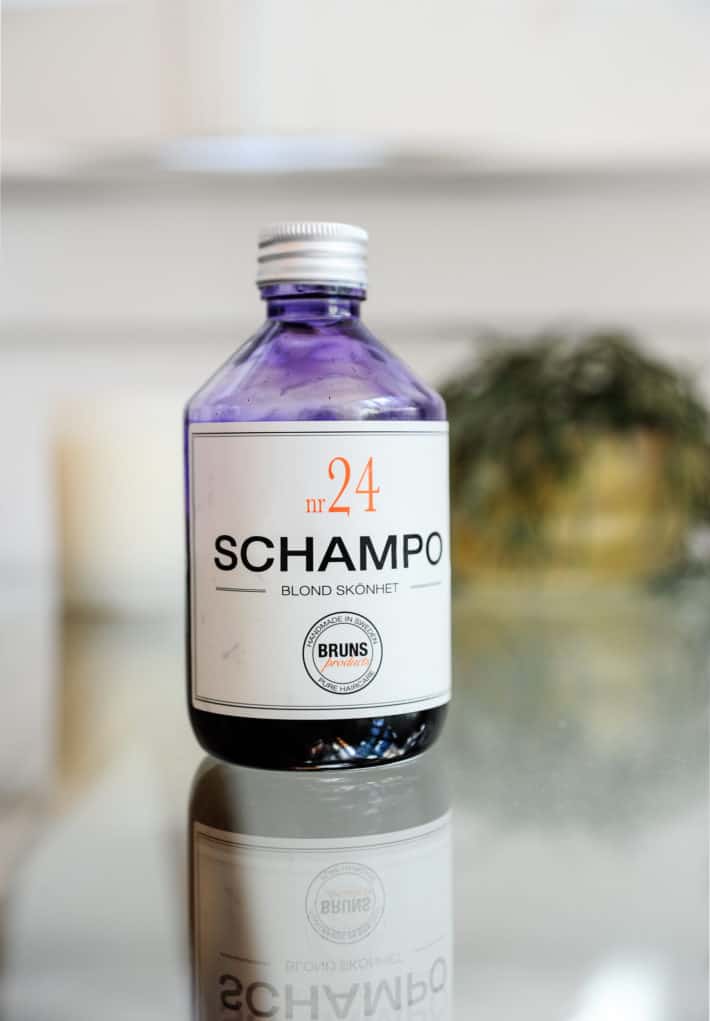 Bruns SCHAMPO N24 shampoo bottle sitting on a glass table