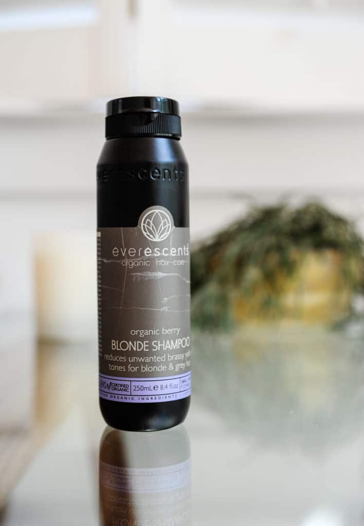 Everessence Organics shampoo bottle sitting on glass table