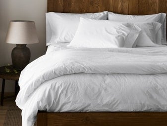 organic white bedsheets and duvet on a bed