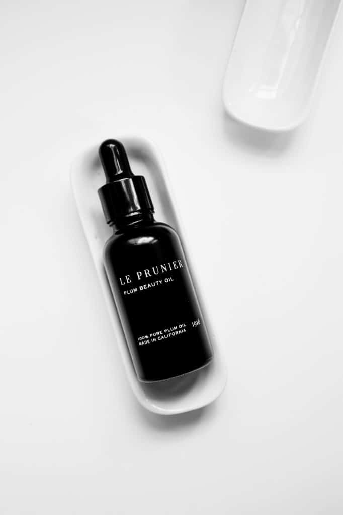 Le Prunier flat lay black bottle on a white background