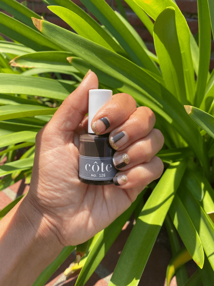 hand holding bottle of Cote warm molten chocolate brown nail polish