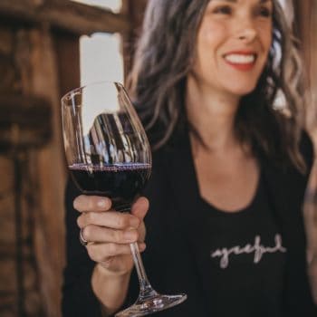 woman holding a glass of wine from dry farm wines
