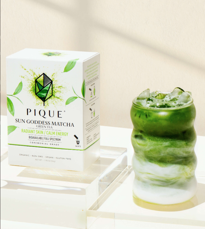 A box of pique tea and glass of it.