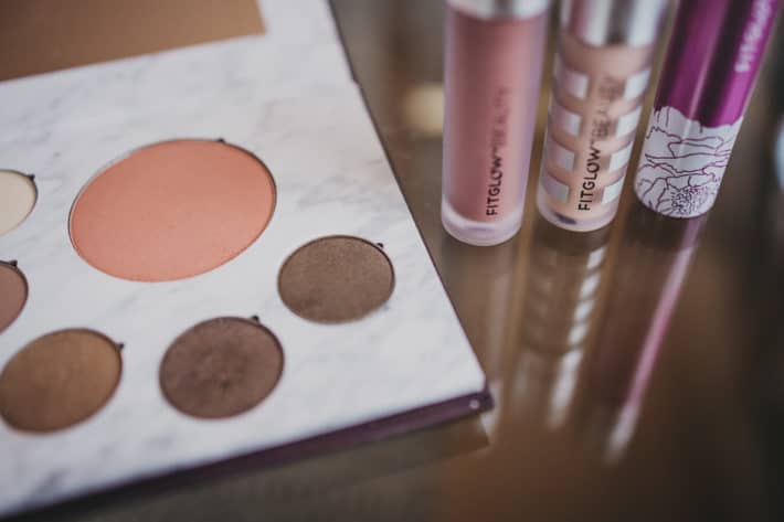four makeup items on a glass table from fitglow