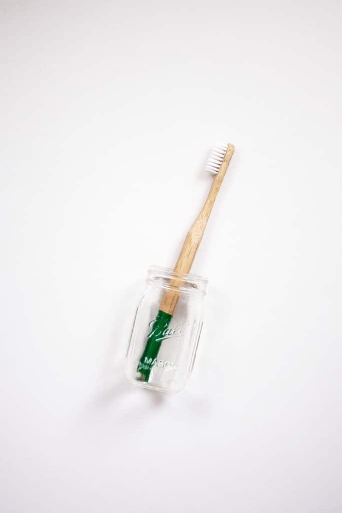 a wooden toothbrush in a mason jar 