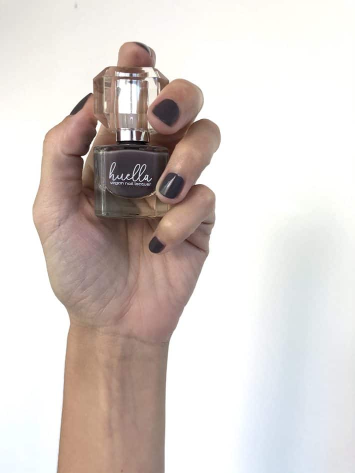 Lisa holds a bottle of Huella Nail Polish in shade Heavenly Lights.