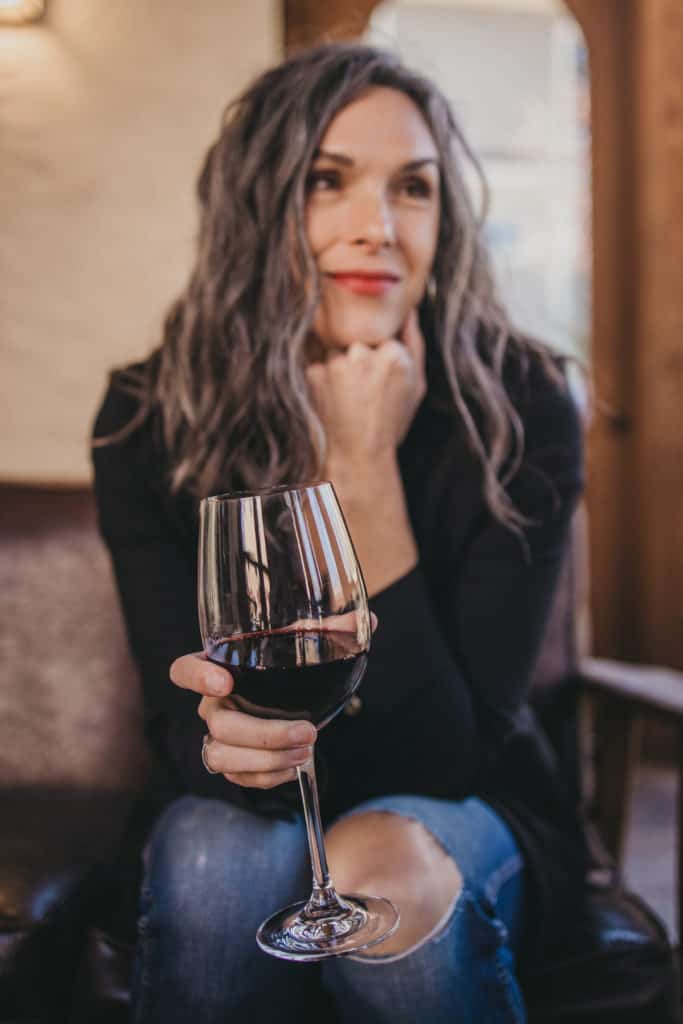 a woman holds a glass of wine
