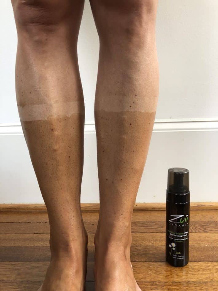 self tanner applied to both legs with the product bottle right next to them