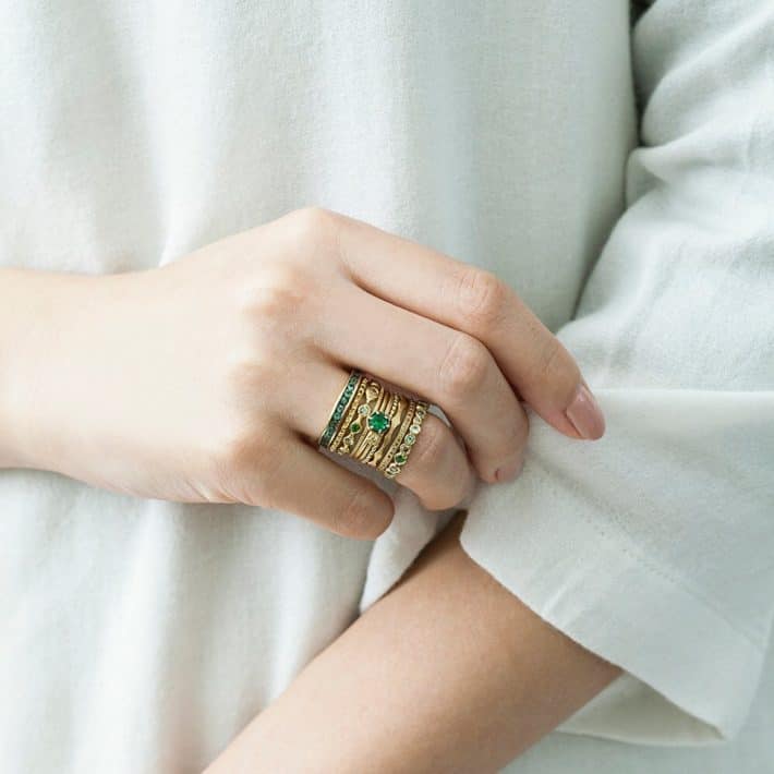 woman wearing sustainable ring with green stones