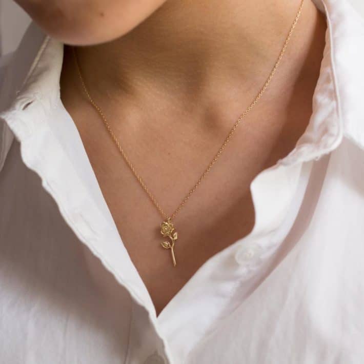 woman wearing sustainable rose shaped necklace