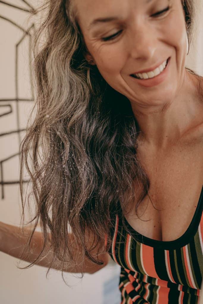 woman with gray and curly hair smiling 