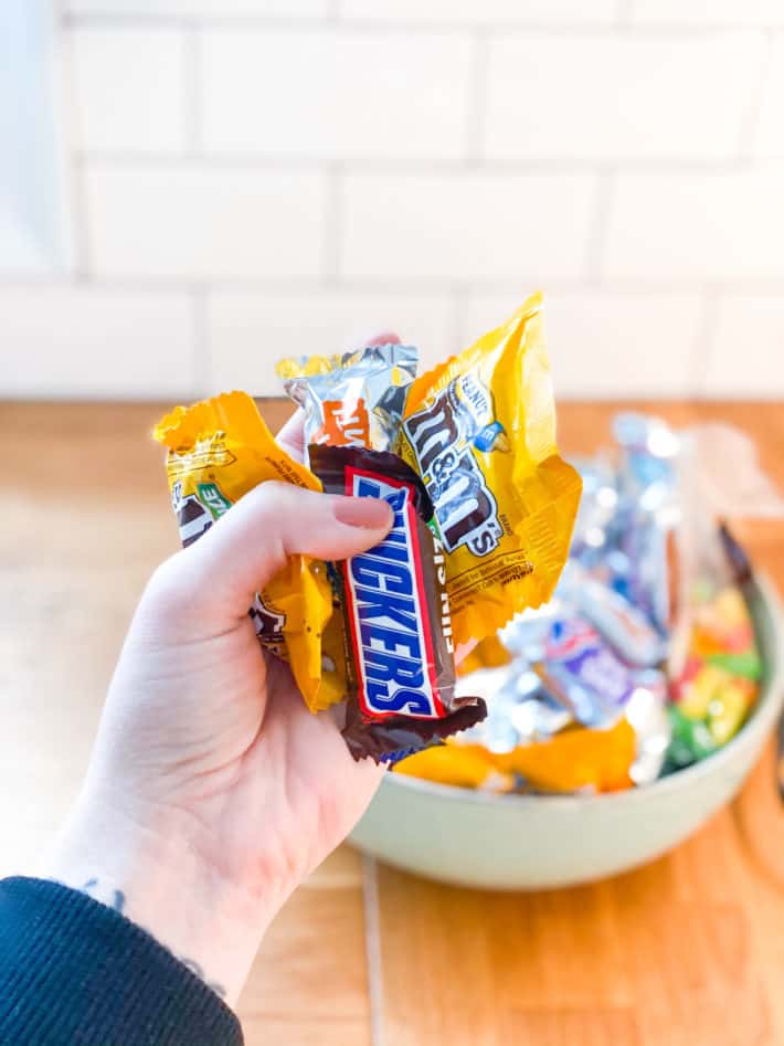 holding a handful of bite-sized wrapped candy 