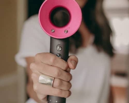 Woman holding hair dryer from Dyson