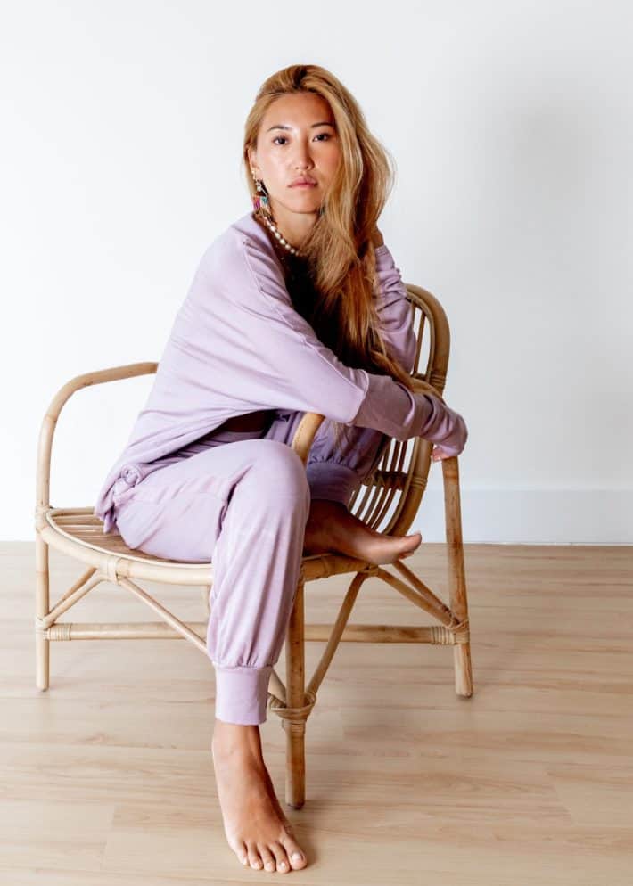 wearing purple loungewear and sitting on a chair 