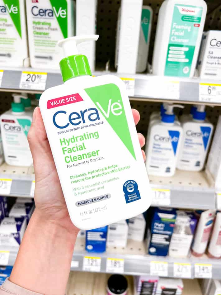 hand holding a bottle of cerave facial cleanser