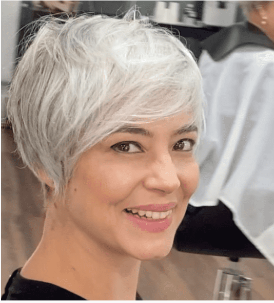 a woman with a short gray hair cut sits in a salon
