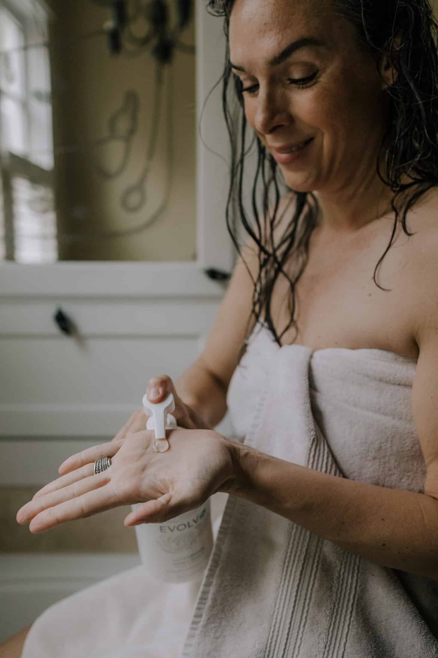 a woman pumps shampoo into her hand