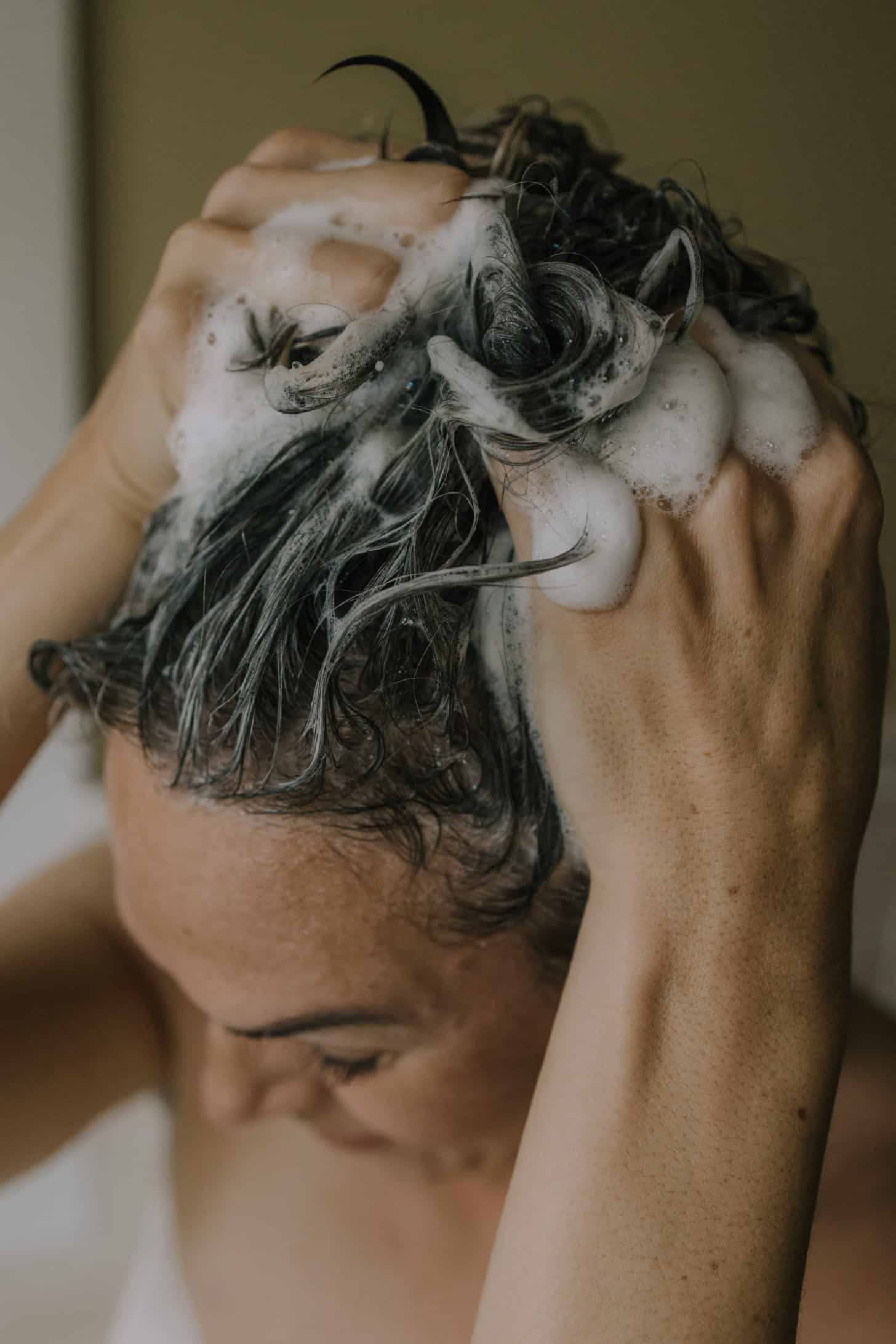 a woman suds up her hair