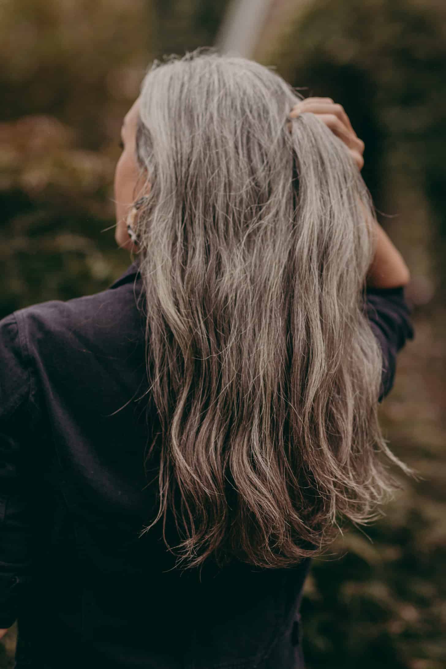 the back of a woman with long wavy gray hair
