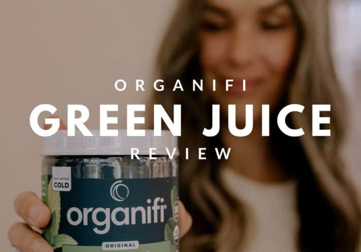 a woman holds a container of organifi green juice