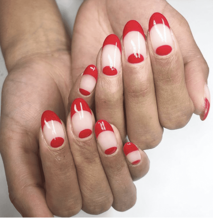 a close up of hands painted with a half moon manicure