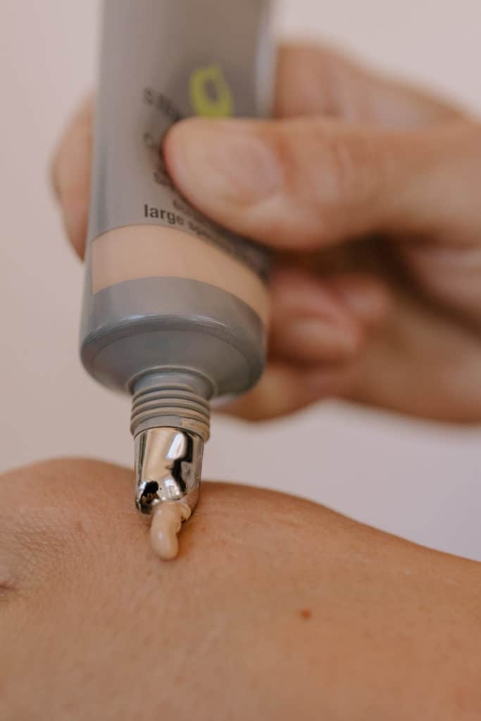 a tube of juice beauty stem cellular cc cream is squeezed out onto a hand