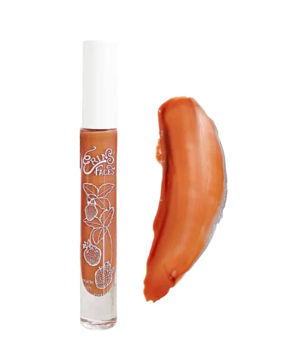 a tube of erin's faces fruit smoothie lip gloss in daybreak (an orangey color)