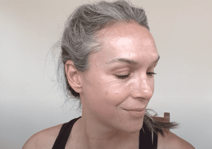 a close up of a woman's face after she applied cocokind face spf