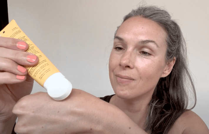 a woman applies cocokind spf to her hand