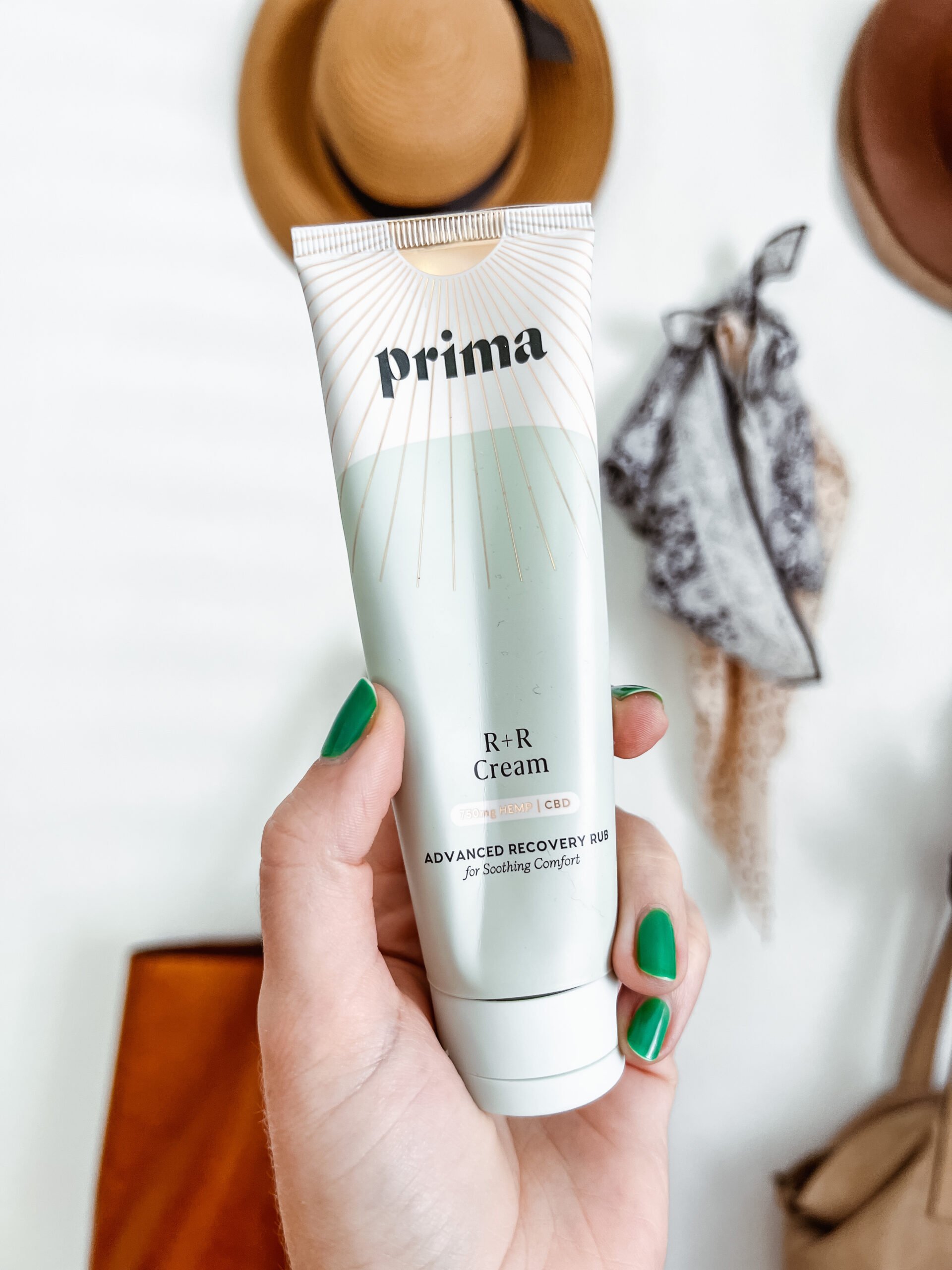 a hand holds up a tube of Prima's R+R cream