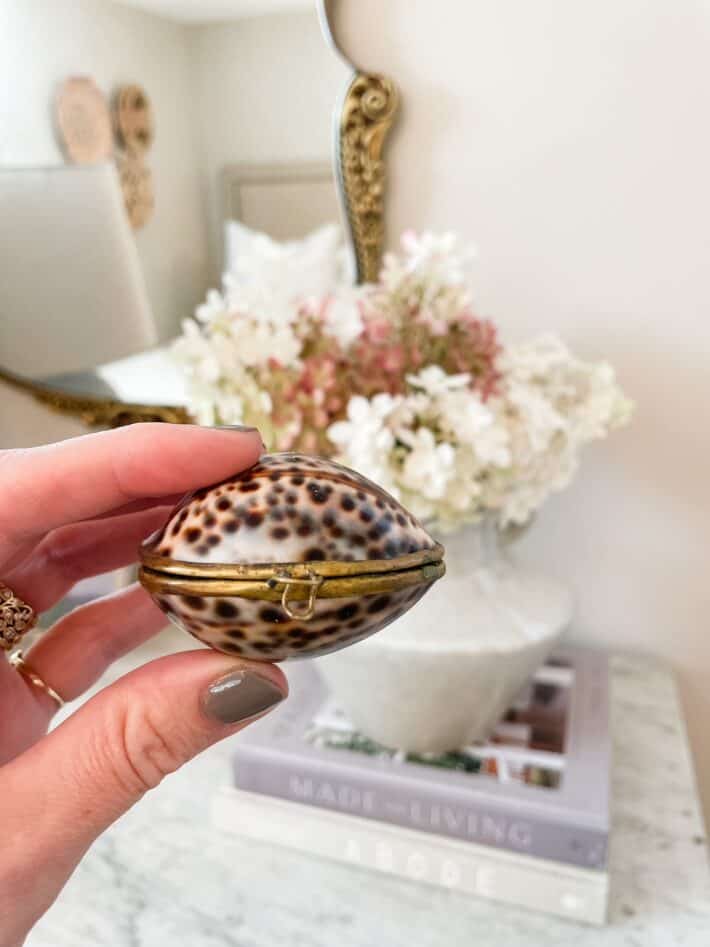 a shell filled with solid perfume is held up