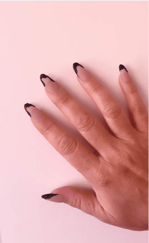 a close up of a hand painted with black tips
