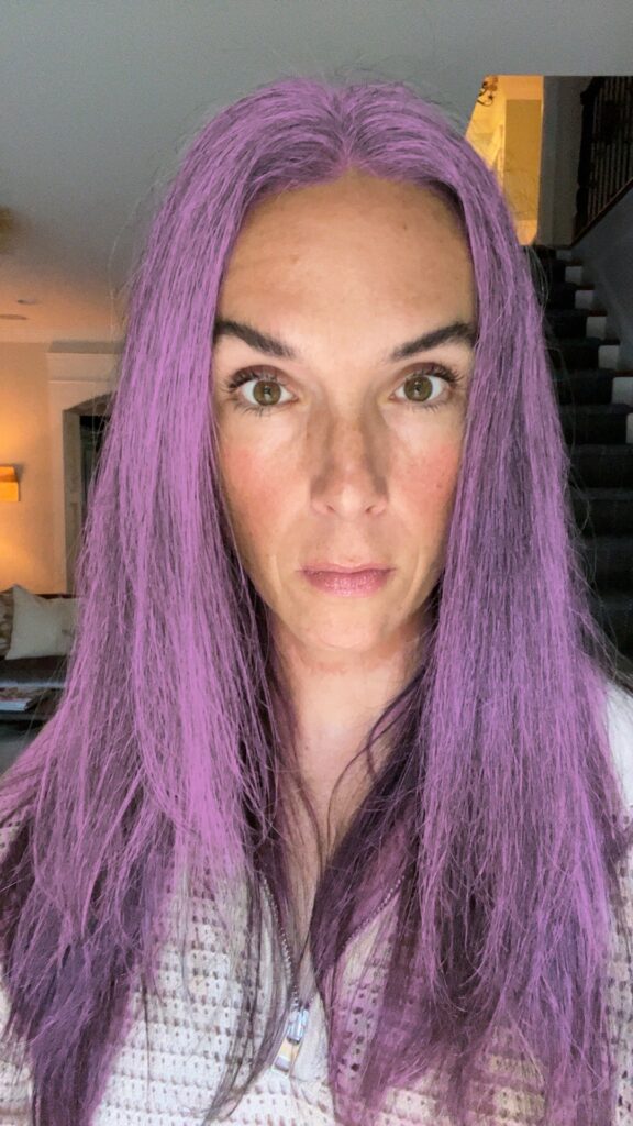 A woman with a purple dye job on a gray hair photo using a hair color changing app.