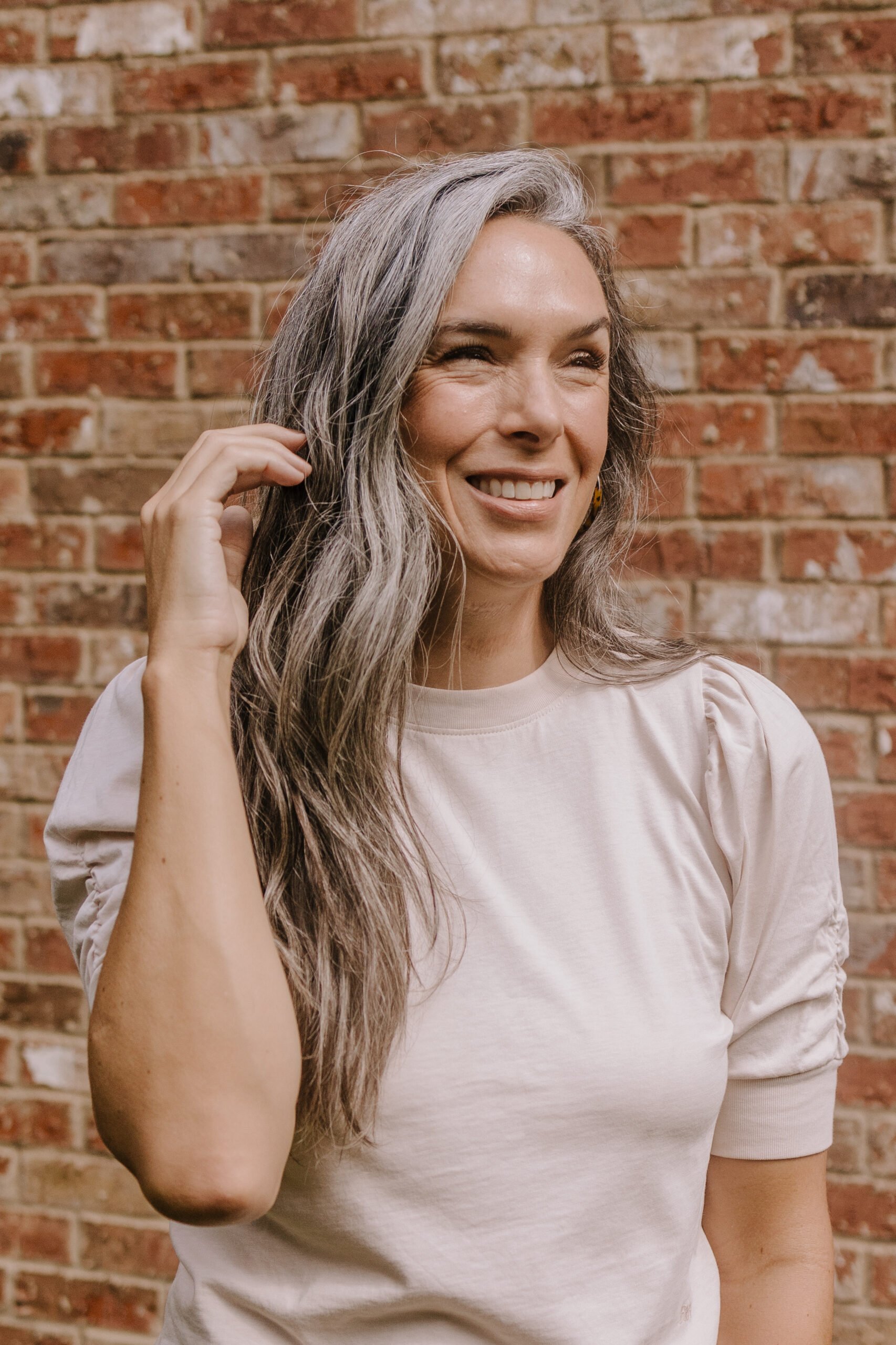 A woman with long gray hair looks off to the side.