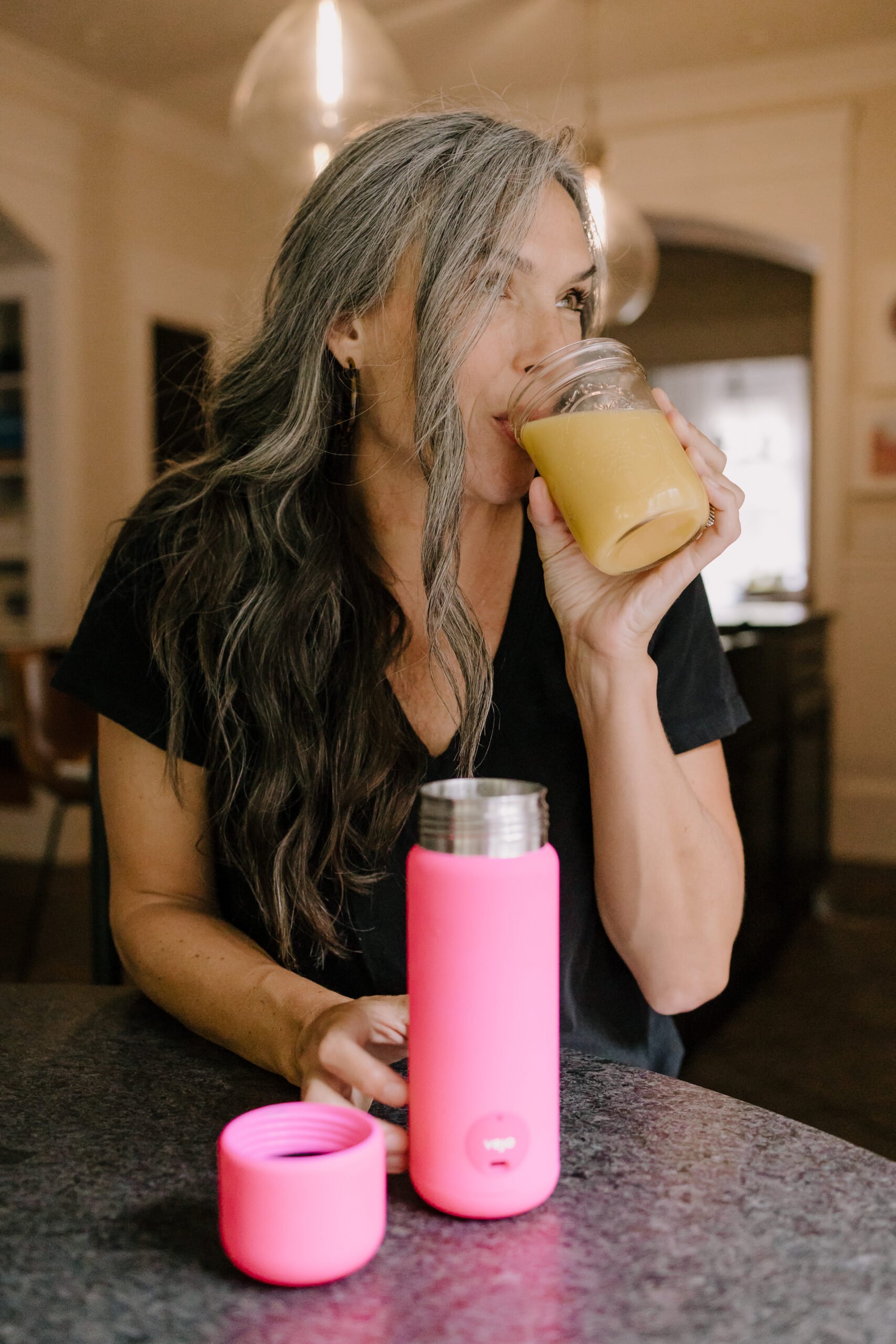 A woman looks off to the side while drinking a Vejo blended drink. 