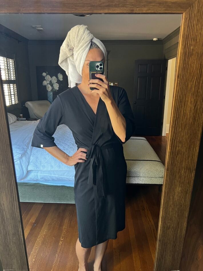 A woman with her head in a towel wears the Leena & Lu Pima Short Robe in black.
